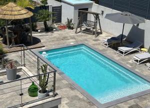 a swimming pool in a yard with an umbrella at LA POINTE D’ASPRETTO in Ajaccio +33 photos