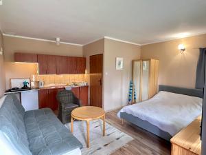 a small room with a bed and a kitchen at Domek Dobrawa- 400m do morza in Międzyzdroje