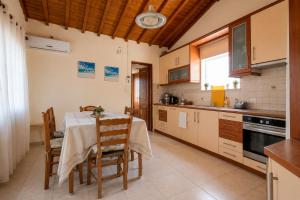 eine Küche mit Tisch und Stühlen in einem Zimmer in der Unterkunft SOFIAS APARTMENTS in LESVOS in Gera