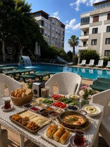 a table with food on it next to a pool at Antalya Apart in Antalya