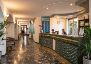 a lobby of a hospital with people sitting at a counter at Eden Torre Canne in Torre Canne