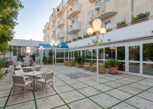 a courtyard with tables and chairs in front of a building at Eden Torre Canne in Torre Canne
