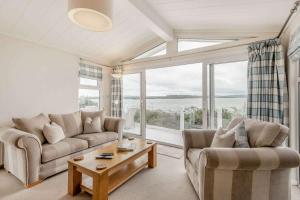 a living room with two couches and a large window at Bay View 2-Bed Lodge with Glorious Harbour View and Balcony in Poole