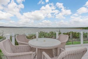 a table and chairs on a patio with a view of the water at Bay View 2-Bed Lodge with Glorious Harbour View and Balcony in Poole +27 photos