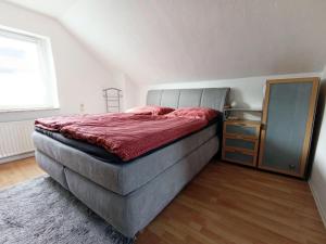 a bedroom with a large bed and a dresser at Ferienhaus-Kassiopeia in Laboe