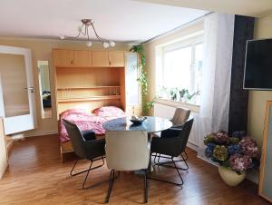 a room with a table and chairs and a bed at Ferienhaus-Kassiopeia in Laboe