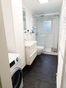a bathroom with a sink and a toilet and a shower at Ferienhaus-Kassiopeia in Laboe +25 photos