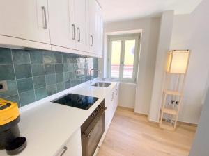 a kitchen with white cabinets and a sink and a window at Metropolis Nextdoor in Vathi
