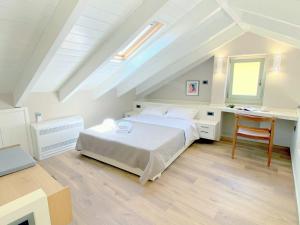 a white bedroom with a bed and a desk and a window at Metropolis Nextdoor in Vathi +35 photos