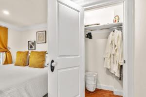 a bedroom with a white bed and a closet at Garden Level 2 bed 2 bath Apartment in Historic District in Savannah +28 photos