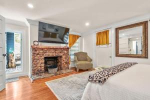 a bedroom with a fireplace and a bed and a tv at Garden Level 2 bed 2 bath Apartment in Historic District in Savannah