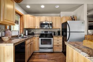 a kitchen with wooden cabinets and a white refrigerator at Glacier River Ranch - South Fork in Columbia Falls