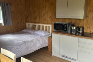 a bedroom with a bed and a microwave on a counter at The Apple Rest in Snitterfield