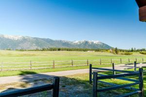 a fence in a field with mountains in the background at Glacier River Ranch - South Fork in Columbia Falls