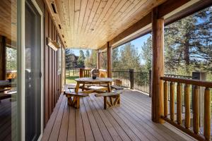 a wooden porch with a table and bench on it at Glacier River Ranch - South Fork in Columbia Falls