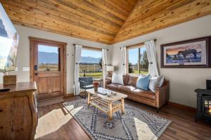 a living room with a couch and a table at Glacier River Ranch - South Fork in Columbia Falls +17 photos