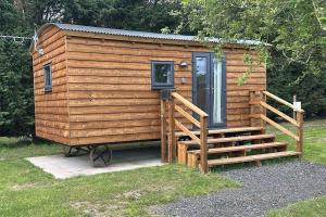 a wooden cabin with a staircase and a door at The Apple Rest in Snitterfield