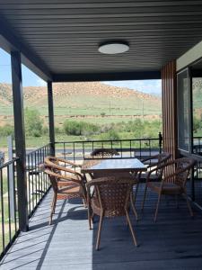a patio with a table and chairs on a deck at Opensky-kolsay 2 in Saty +6 photos