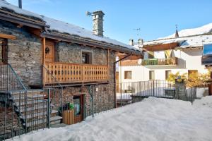 a stone house with a balcony and a staircase at Chalet vista Monte Bianco in La Salle