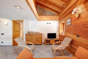 a living room with chairs and a tv and a wooden wall at Chalet vista Monte Bianco in La Salle