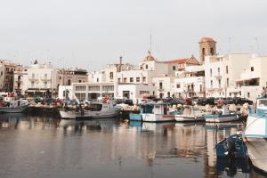 a group of boats docked in a harbor with buildings at La Foresteria in Mola di Bari