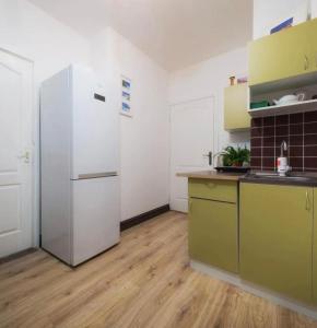 a kitchen with a white refrigerator and a wooden floor at Good Dreams in Kyiv
