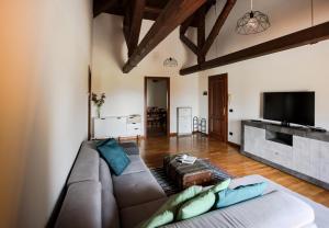 a living room with a couch and a flat screen tv at Agriturismo Rechsteiner in Ponte di Piave