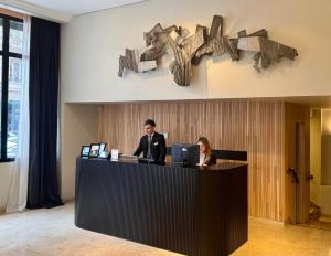 a man and a woman sitting at a reception desk at Carles Hotel in Buenos Aires