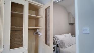 a small room with a bed and a closet at Hallbottom Farm Cottage in Stokenchurch