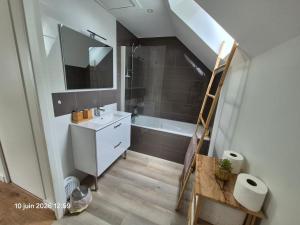 a bathroom with a sink and a bath tub at Chambres d'hotes PROCHE CIRCUIT in Arnage +18 photos