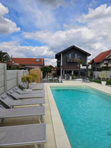 a swimming pool with lounge chairs and a house at Art baile felix in Cordău