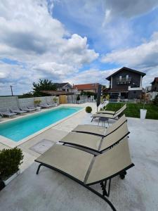 a group of lounge chairs next to a swimming pool at Art baile felix in Cordău