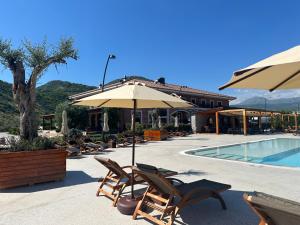 a patio with chairs and umbrellas next to a pool at Porta e Alpeve in Gradec