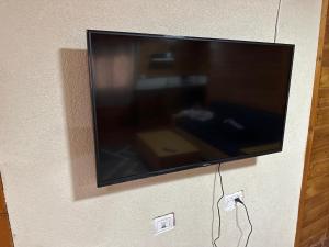 a flat screen tv hanging on a wall at carmel cabins suite 6 in Yājur