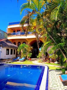 a resort with a swimming pool in front of a building at Pousada Presidente Hotel in Canoa Quebrada