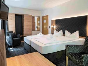 a hotel room with a large bed and a chair at Hotel Zum Steinhof in Bad Blankenburg