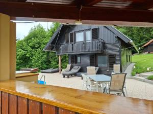 a house with a patio with a table and chairs at House Gore VVV in Dol pri Hrastniku