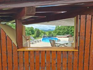 a wooden deck with a table and chairs and a pool at House Gore VVV in Dol pri Hrastniku