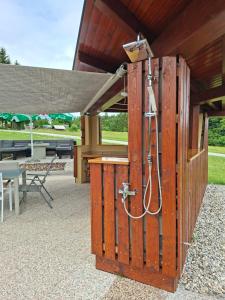 a shower in a wooden structure with a table at House Gore VVV in Dol pri Hrastniku +28 photos