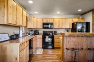a kitchen with wooden cabinets and black appliances at Glacier River Ranch - Flathead in Columbia Falls