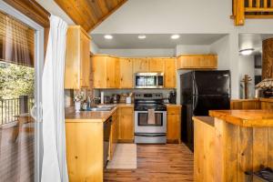 a kitchen with wooden cabinets and a black refrigerator at Glacier River Ranch - Middle Fork in Columbia Falls
