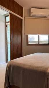 a bedroom with a bed with a window and a fan at Ocean Flat 707 - Praia da Costa in Vila Velha +8 photos