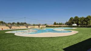a swimming pool in a grassy field at Las cuevas de María in Bácor