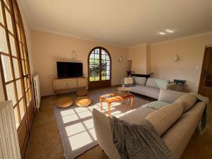 a living room with a couch and a tv at Los Arcos in Annonay
