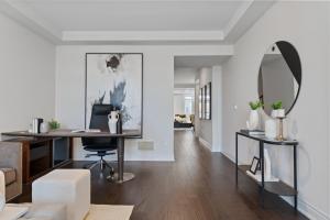 a living room with a desk and a mirror at The Oakville House in Oakville