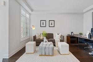 a white living room with a couch and a table at The Oakville House in Oakville