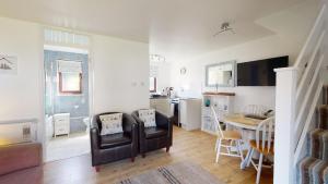 a kitchen and living room with a table and chairs at 35 Strawberry Hill, Tolroy Manor in Hayle