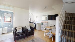 a living room and kitchen with a couch and a table at 35 Strawberry Hill, Tolroy Manor in Hayle