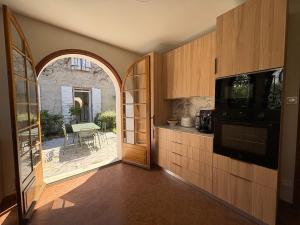 an open door to a kitchen with an archway at Los Arcos in Annonay