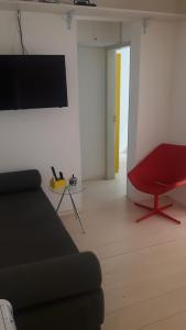 a living room with a couch and a red chair at Balkony 407 - Três quartos Perto UNB in Brasilia